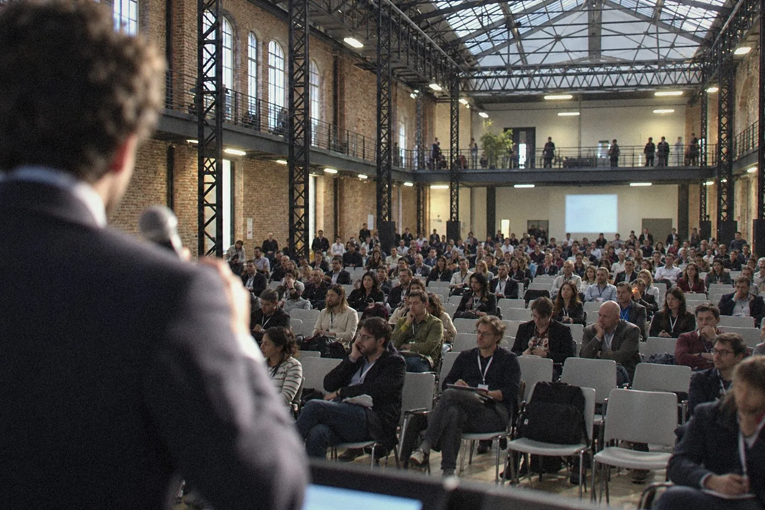 Speaker facing the audience in a former industrial hall