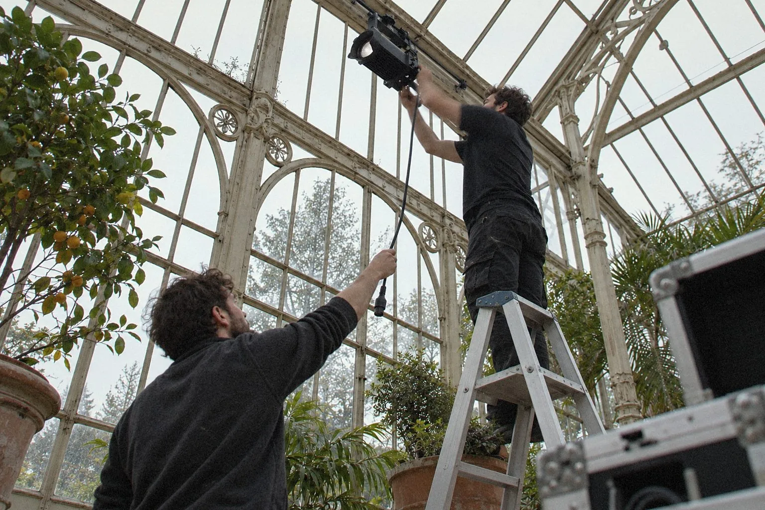 Technicians rigging a light in an orangery the day before the seminar