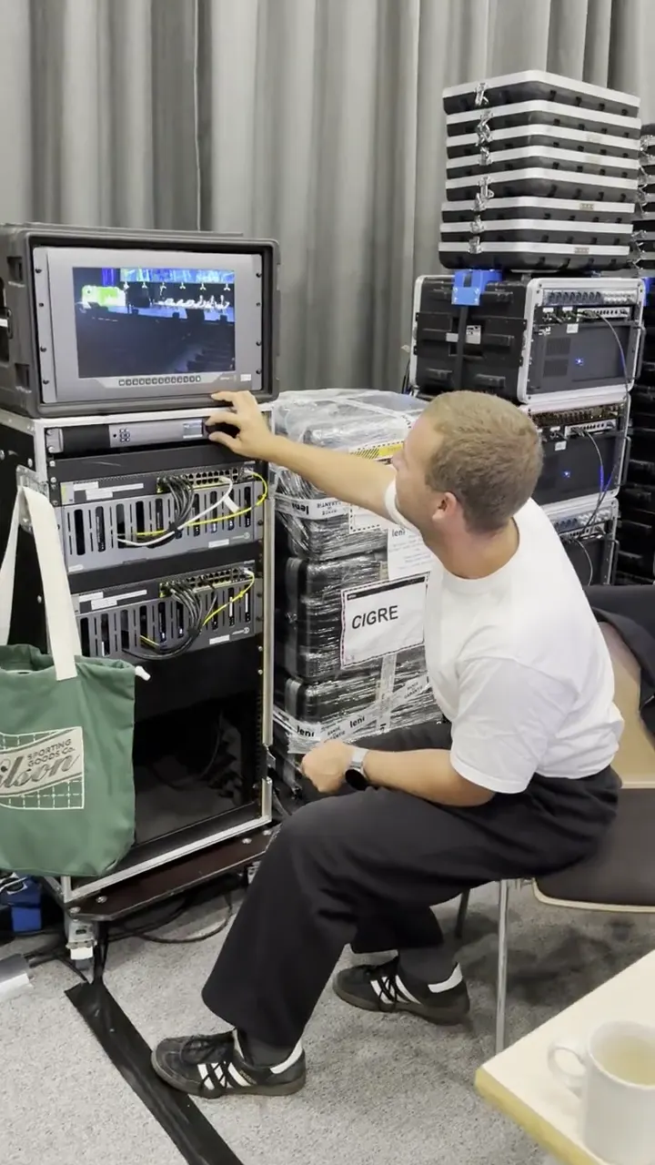 Technician cabling a video rack before the event